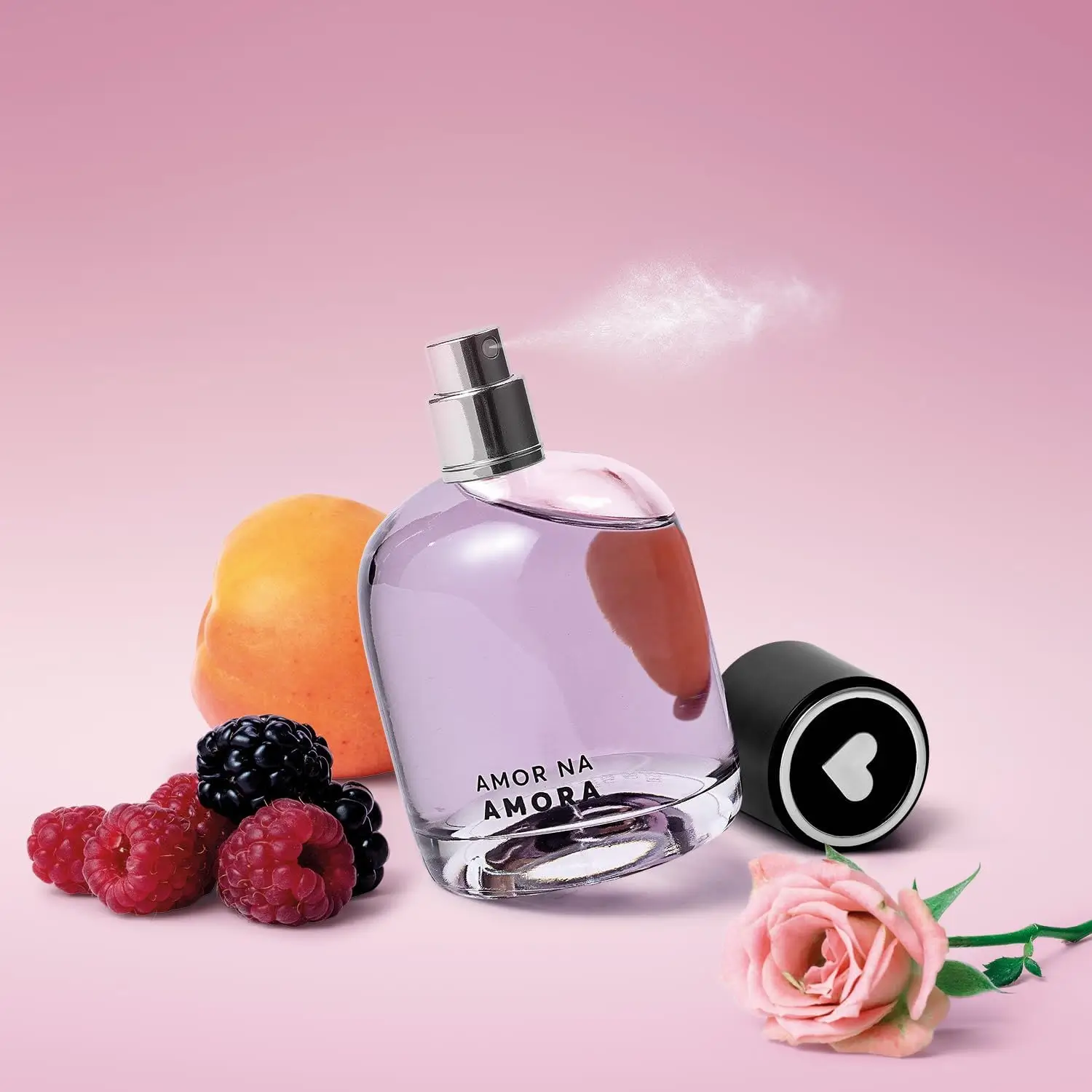 Frasco do perfume Amor na Amora da Quem Disse, Berenice? com frutas vermelhas, pêssego e rosa sobre fundo rosa.